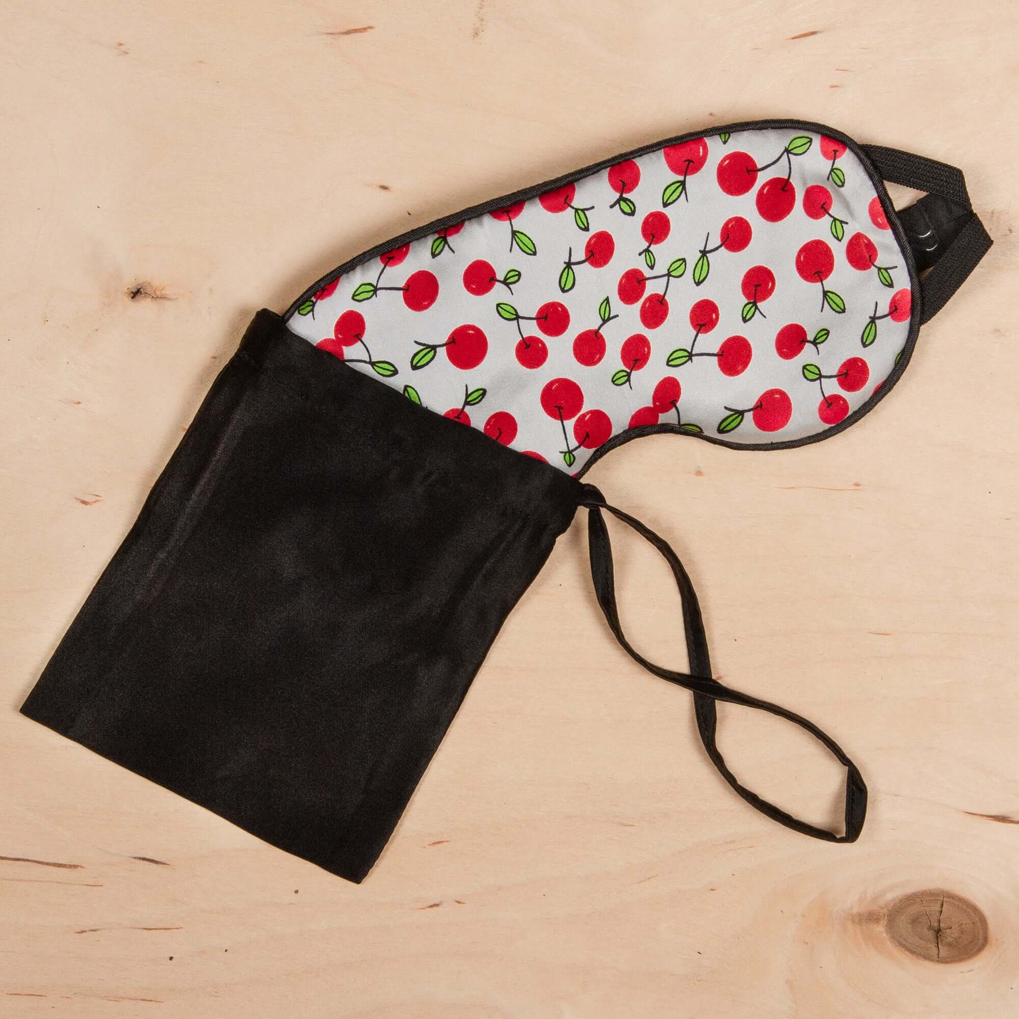 Colorful cherry-patterned 100% silk sleep mask storage case with black fabric, perfect for travel and organization.