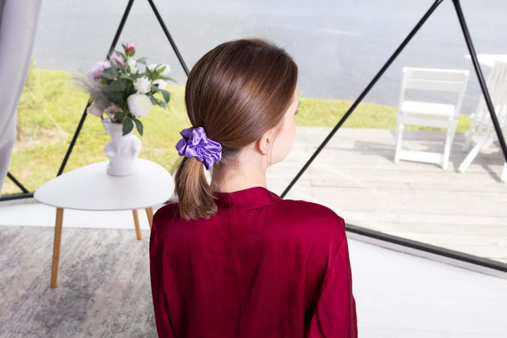 Model wearing a pure mulberry silk scrunchie in purple, showcasing its high elasticity and elegant style.