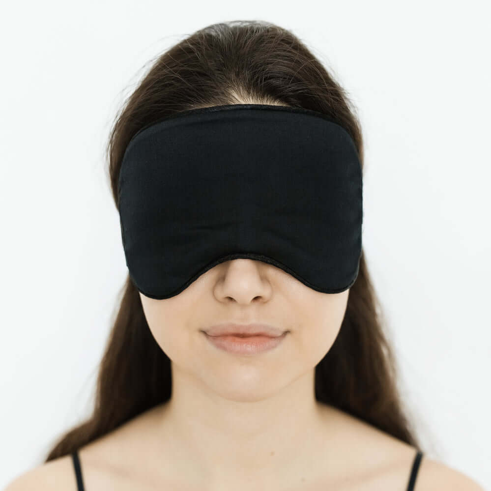 Quietstore organic cotton sleep mask on a model, featuring a non-slip strap for comfort and light blockage.