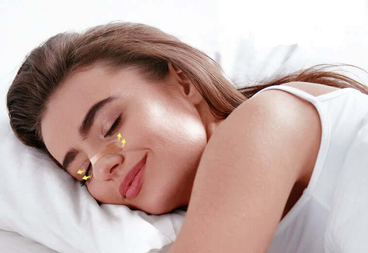 Woman sleeping peacefully with Breathe Easy nasal strips to reduce snoring and relieve congestion.