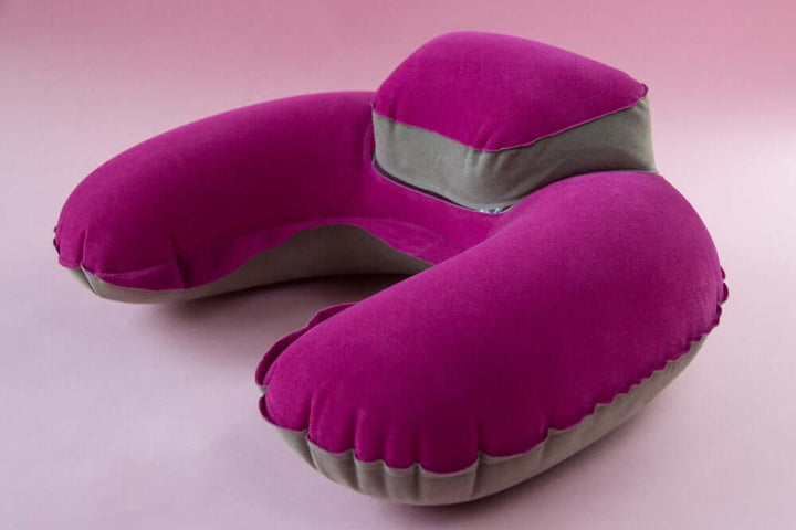 Inflatable travel neck pillow with headrest in vibrant pink for ultimate comfort during travel.