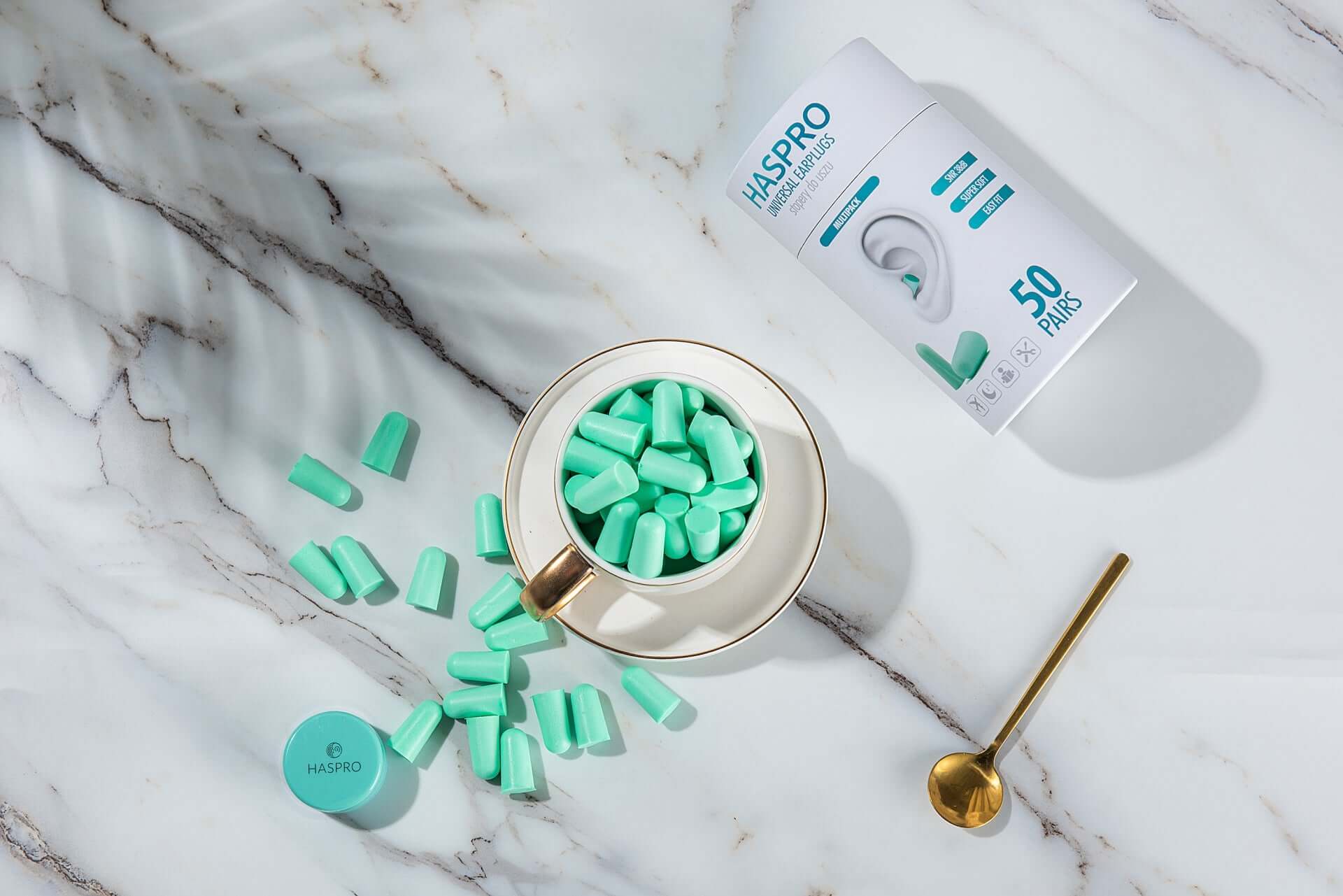 HASPRO Tube50 foam earplugs in a cup, showcasing 50 pairs of mint green earplugs for noise reduction.