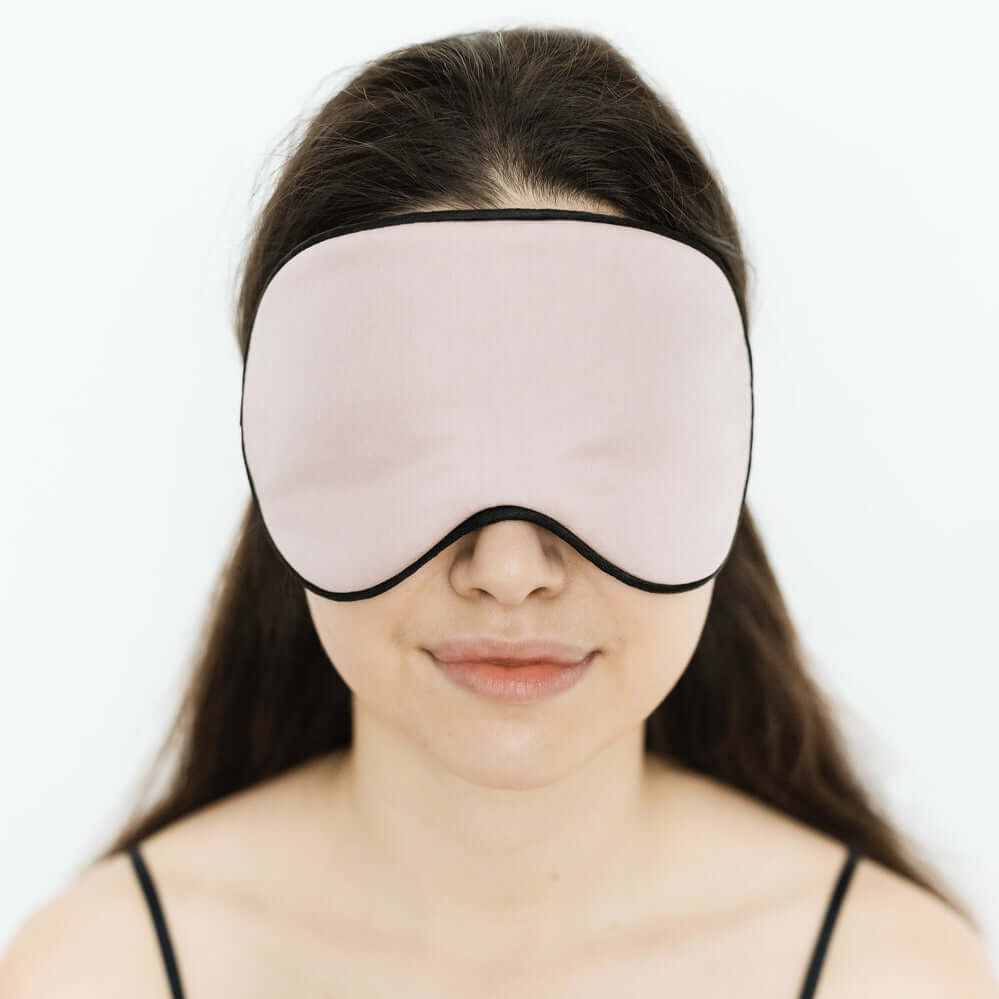 Woman wearing Quietstore organic cotton sleep mask for comfortable, light-blocking sleep.