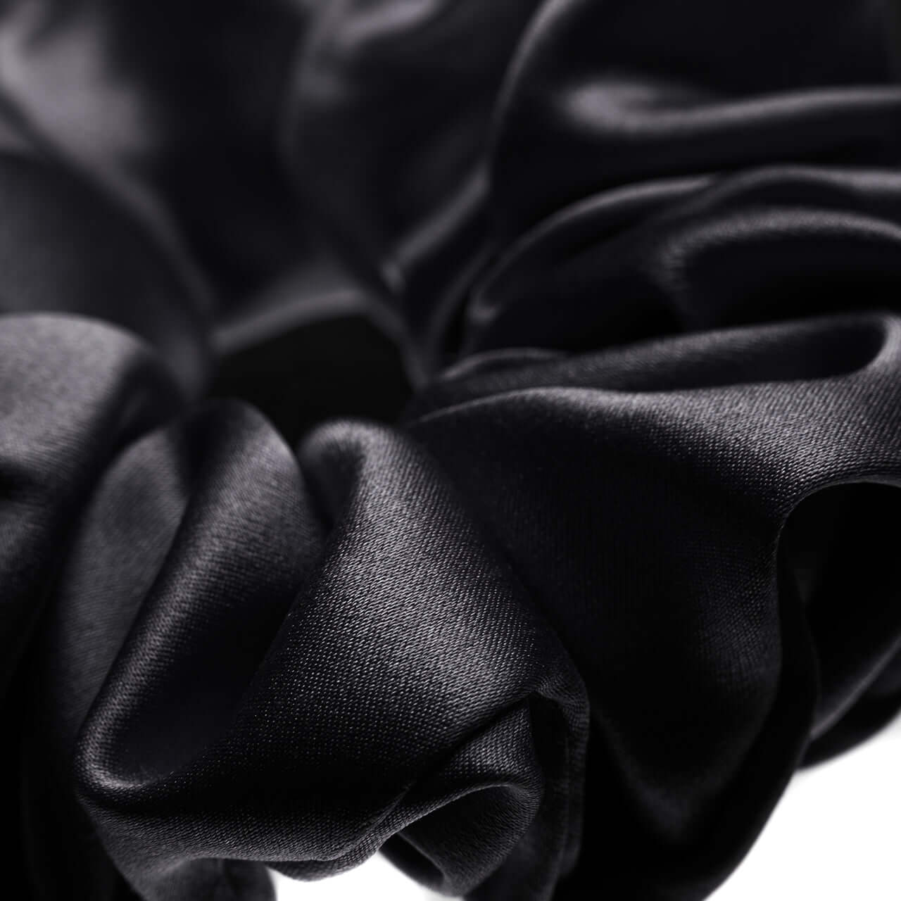 Close-up of a black pure Mulberry silk scrunchie, showcasing its smooth texture and luxurious shine.