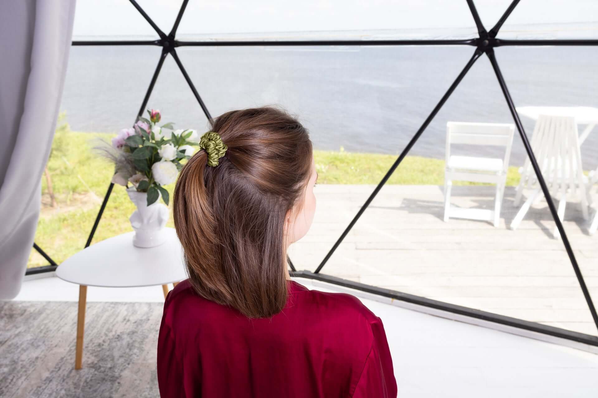 Woman with a Pure Mulberry Silk Scrunchie in a ponytail, enjoying a scenic view by the water.