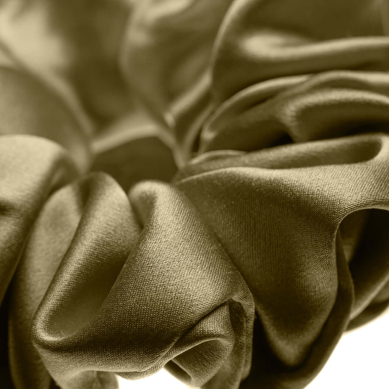 Close-up of a large pure Mulberry silk scrunchie in golden hue, showcasing its smooth texture and elasticity.