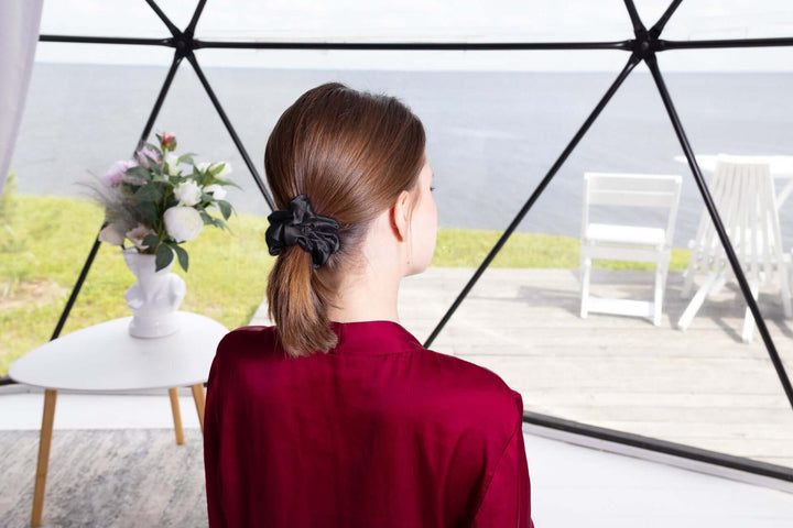Model wearing a pure mulberry silk scrunchie in a ponytail, showcasing its elegant design and elasticity.