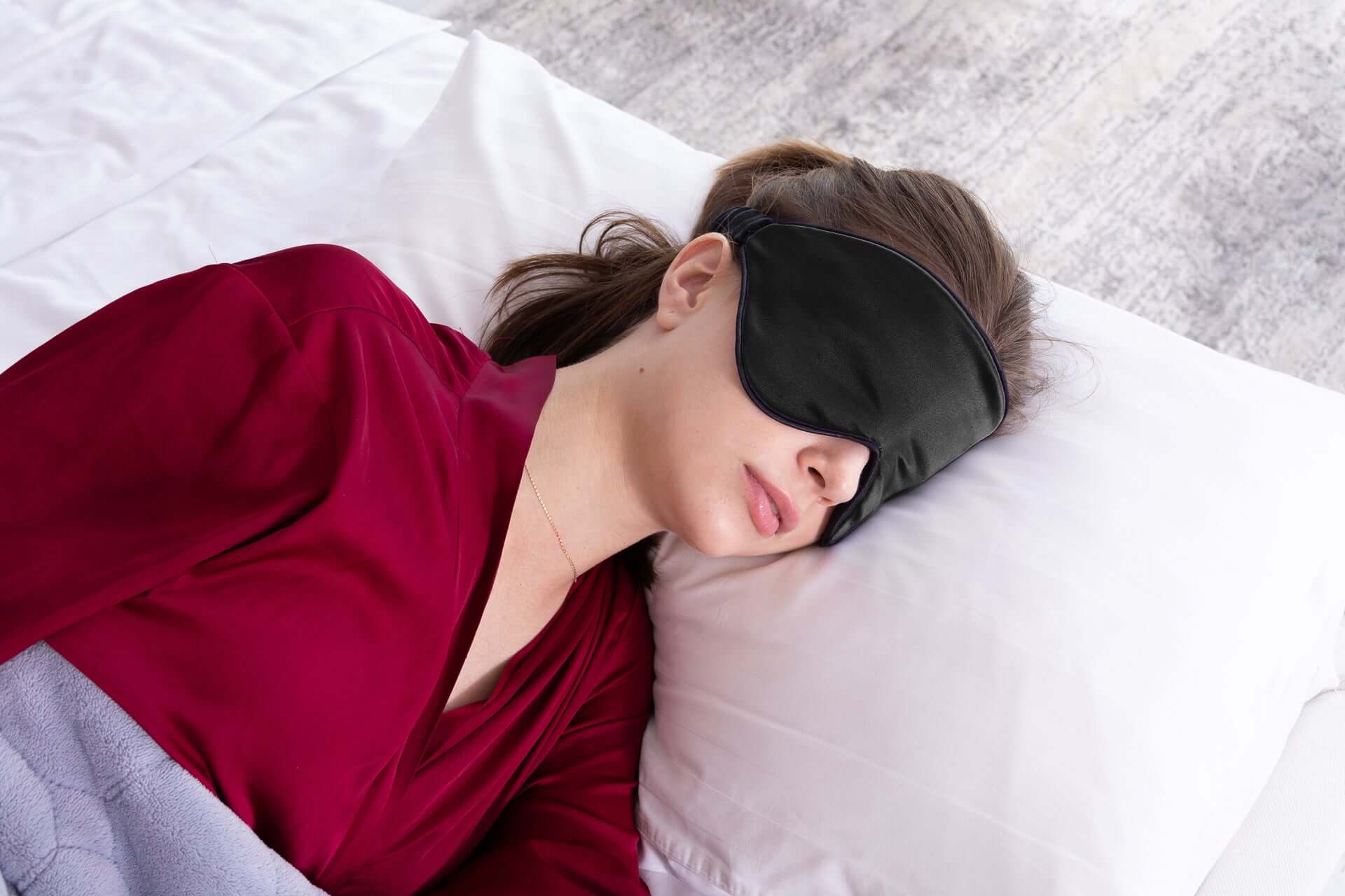 Woman sleeping with Quietstore 3.0 silk sleep mask, promoting restful sleep and comfort with non-slip design.