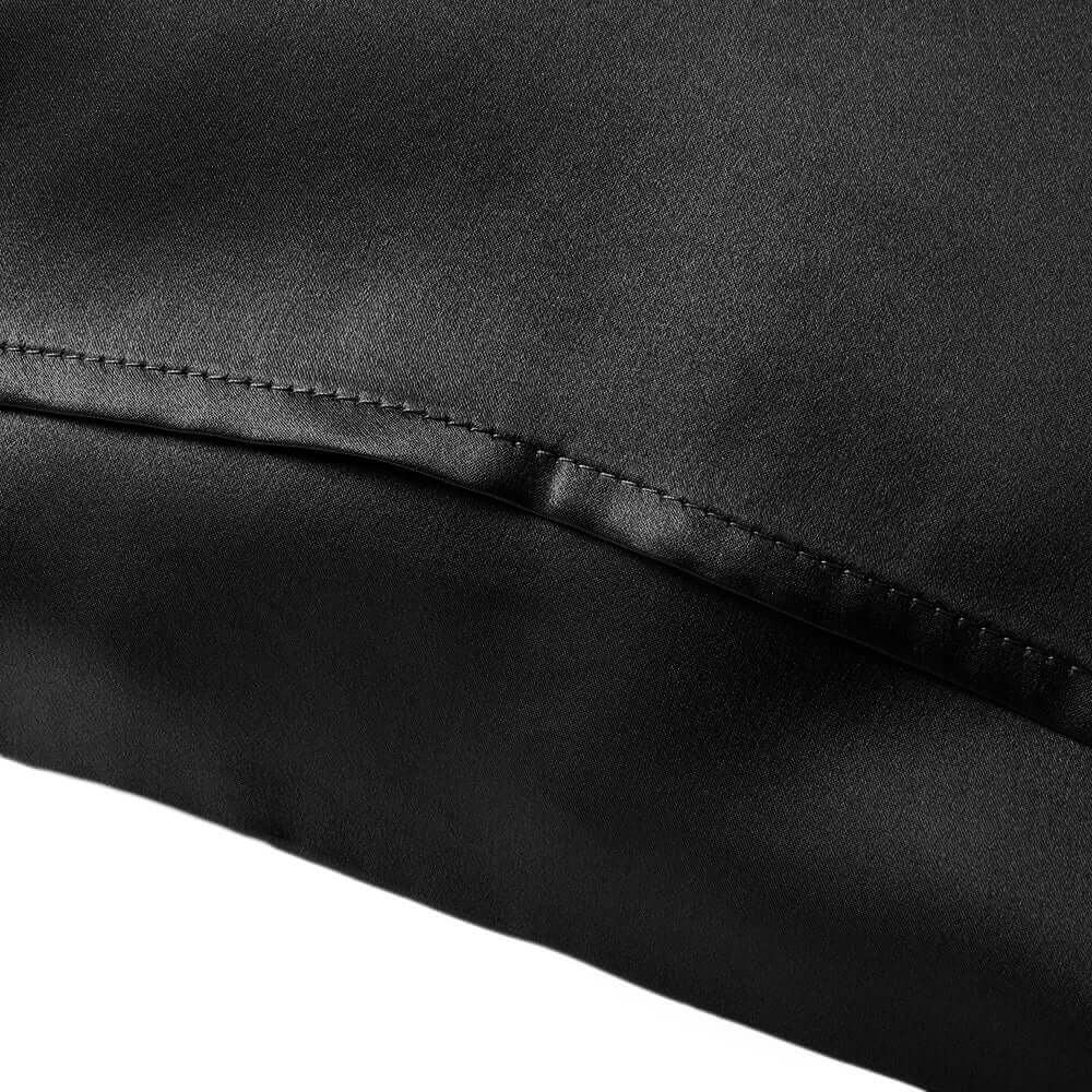 Close-up of a black silk pillowcase showcasing smooth texture and fine stitching.