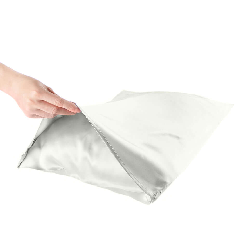 Hand holding a Quietstore mulberry silk pillowcase, highlighting its smooth texture for hair and skin health.
