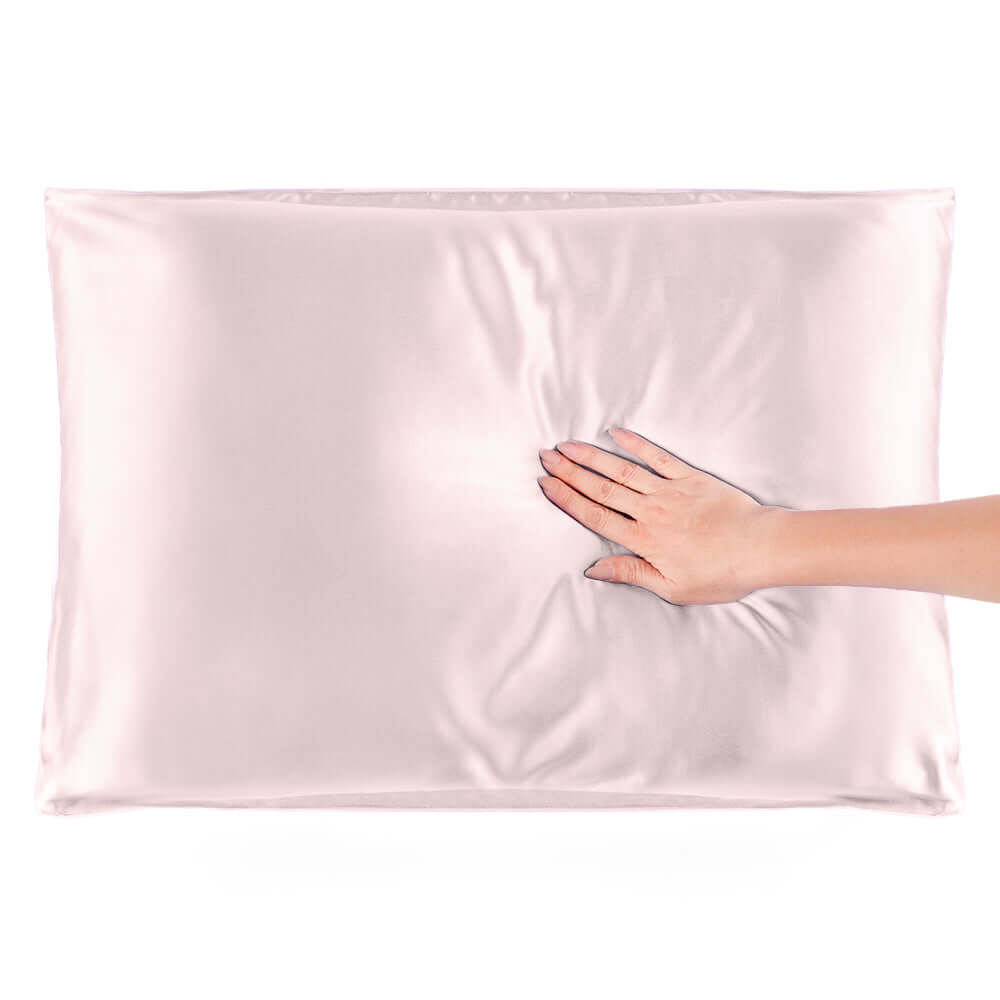 Quietstore mulberry silk pillowcase showcasing softness and comfort with a hand resting on its surface.
