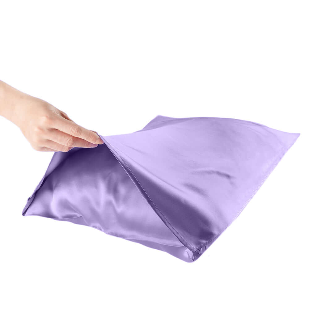 Hand holding a lavender quietstore mulberry silk pillowcase for hair and skin care.
