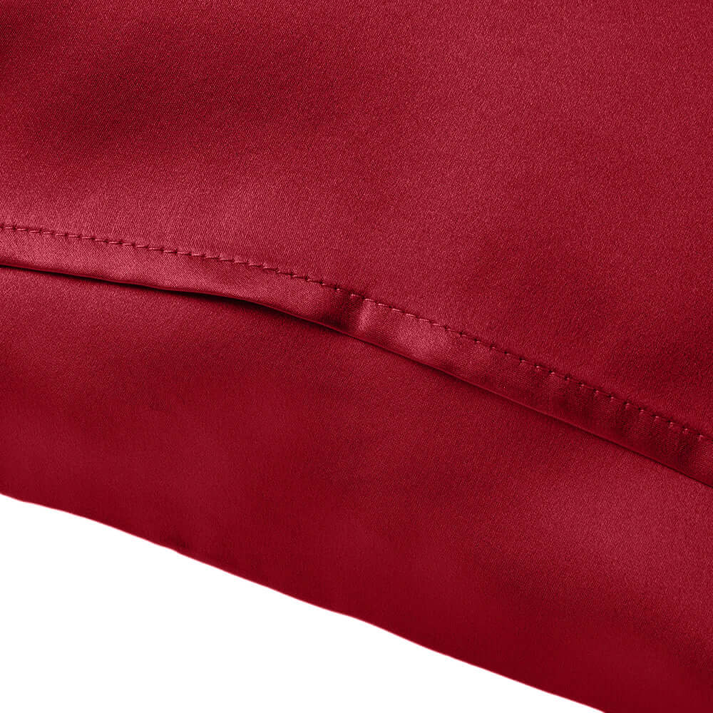 Close-up of a rich red silky pillowcase, showcasing its smooth texture and elegant finish.