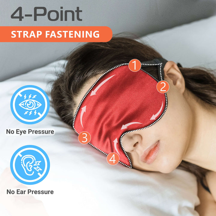 Woman wearing a red silk sleep mask highlighting the 4-point strap fastening for no eye and ear pressure.