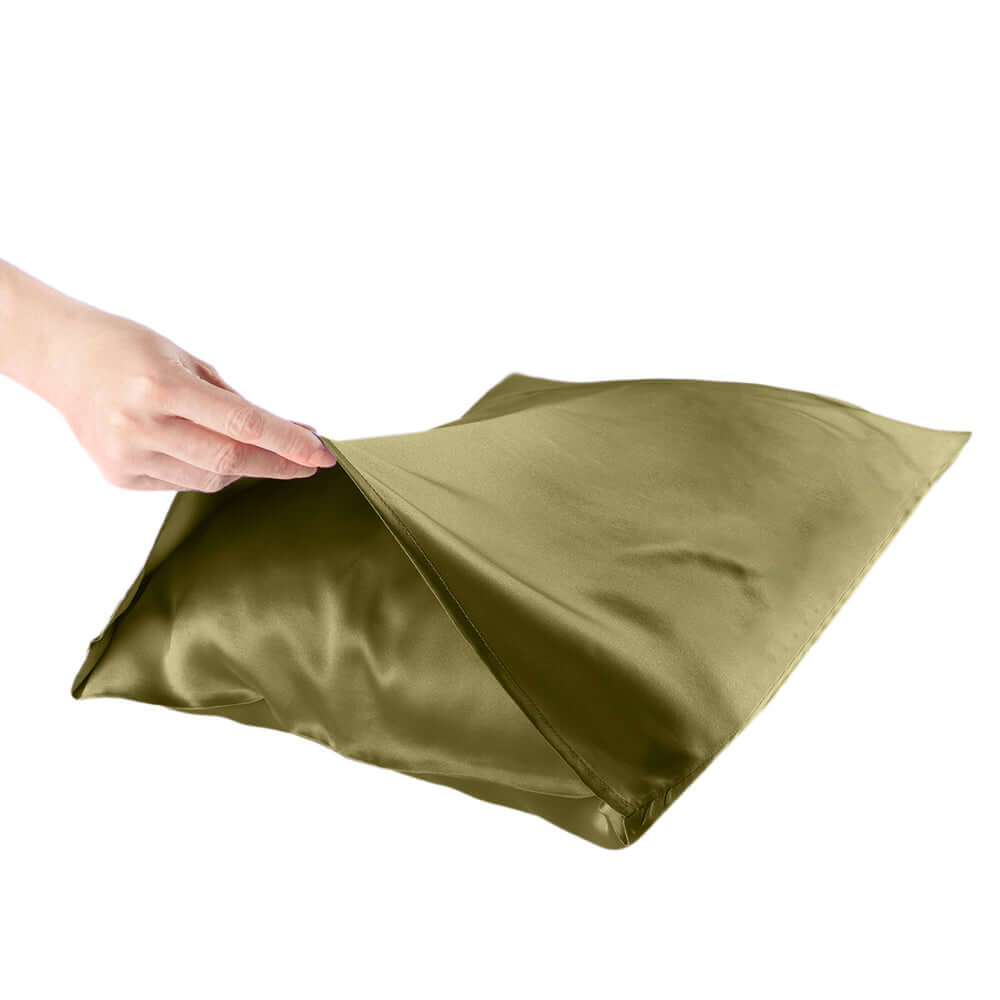 Hand holding an olive green mulberry silk pillowcase, showcasing its soft texture for better hair and skin health.