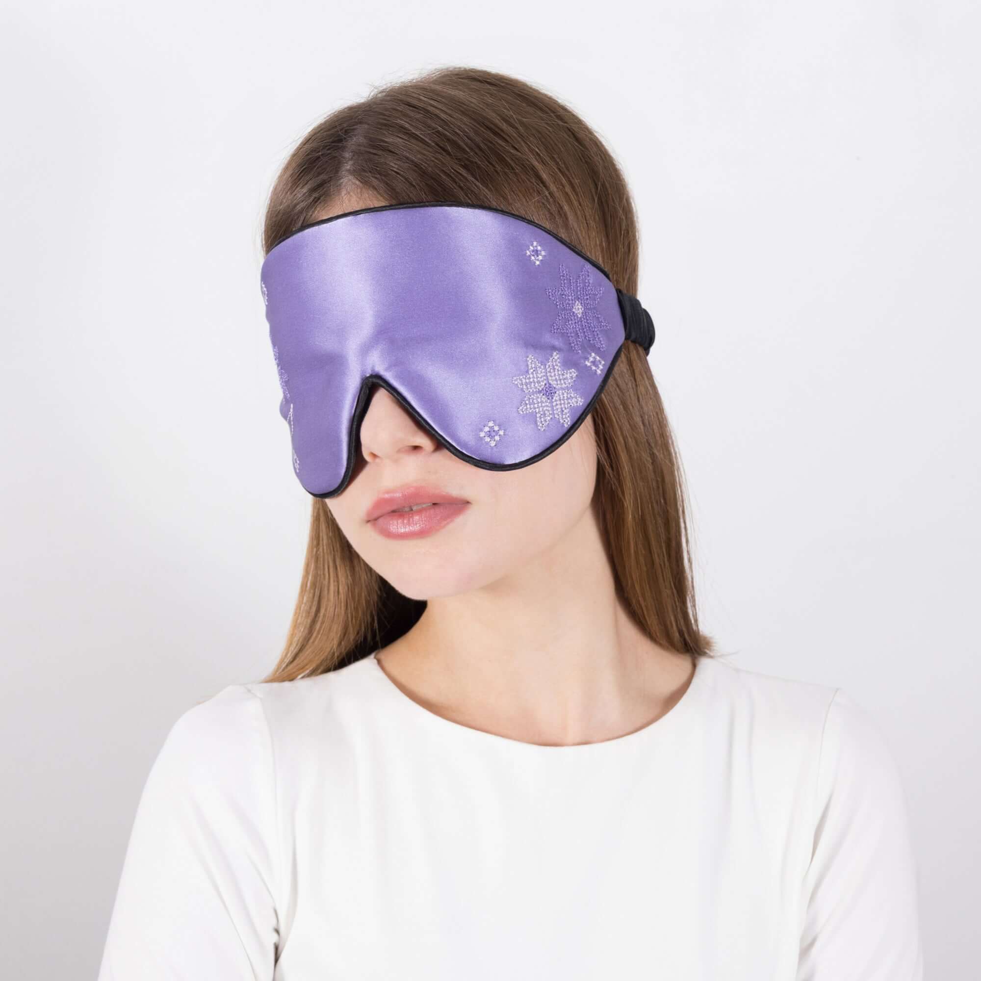 Woman wearing Quietstore 3.1 Silk Sleep Mask with Ukrainian embroidery, made from 100% Mulberry silk.