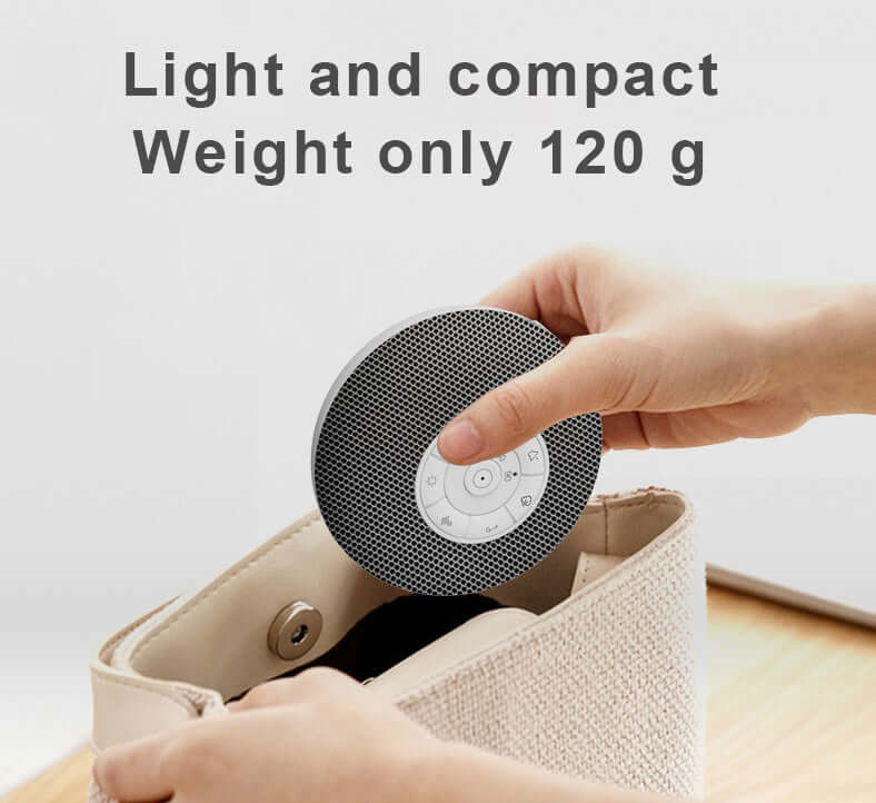 Compact Tuodi white noise sound machine being placed into a bag, highlighting its lightweight design of 120g.